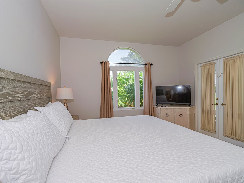 5035 Harmony Circle, Unit 101 Vero Beach, FL 32967 - Photo 18 of 36 a bedroom with a bed and a flat screen tv