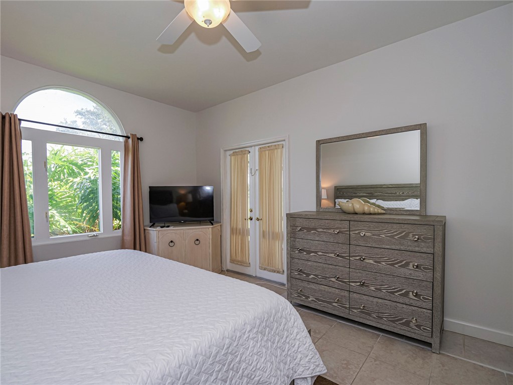 5035 Harmony Circle, Unit 101 Vero Beach, FL 32967 - Photo 19 of 36 a bedroom with a bed and a flat screen tv