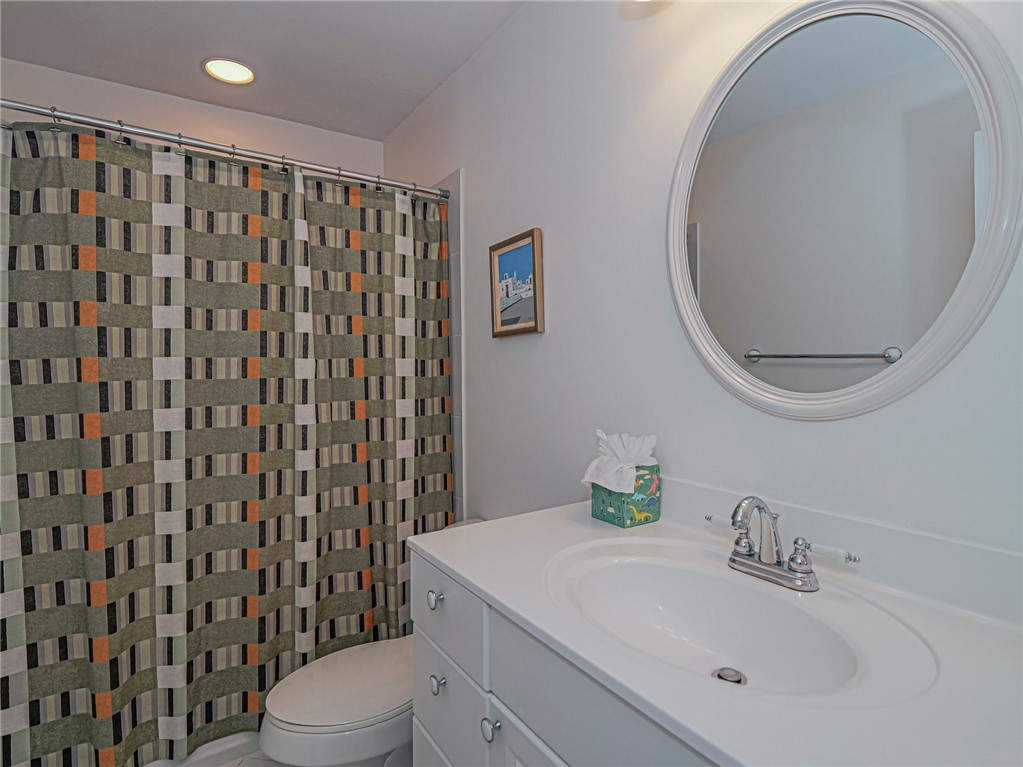5035 Harmony Circle, Unit 101 Vero Beach, FL 32967 - Photo 24 of 36 a bathroom with a sink a toilet and a mirror