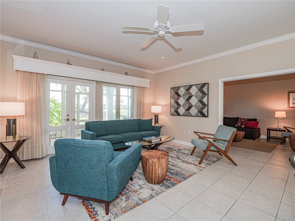 5035 Harmony Circle, Unit 101 Vero Beach, FL 32967 - Photo 7 of 36 a living room with furniture and a chandelier