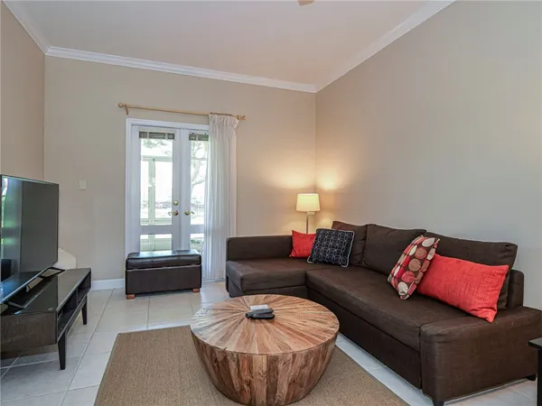 a living room with furniture a flat screen tv and a window
