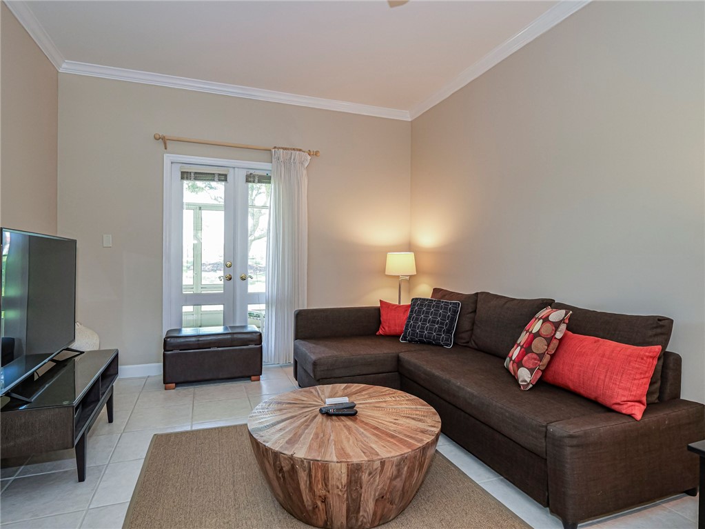 5035 Harmony Circle, Unit 101 Vero Beach, FL 32967 - Photo 8 of 36 a living room with furniture a flat screen tv and a window