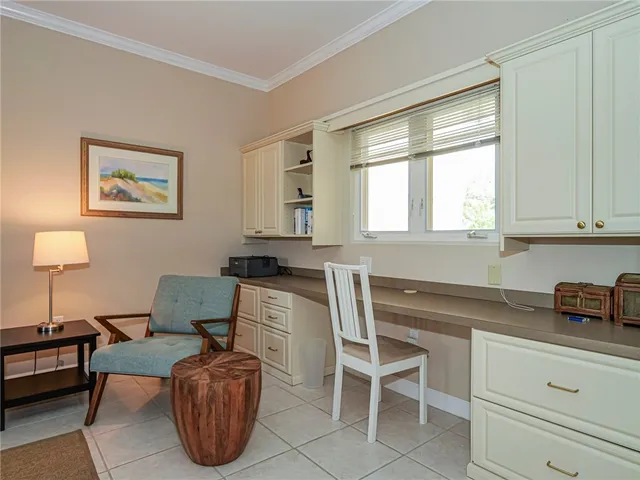 a kitchen with a chair and white cabinets