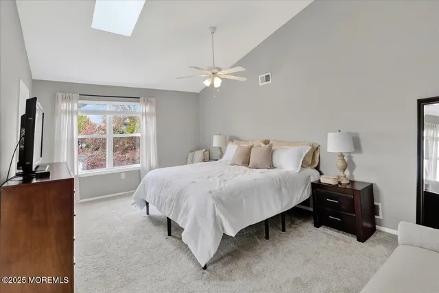 a bedroom with a bed and a flat tv screen on dresser