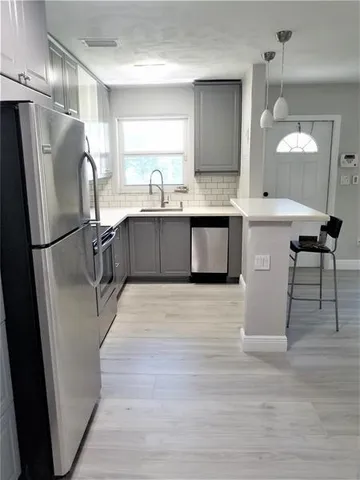 a kitchen with a sink refrigerator and cabinets