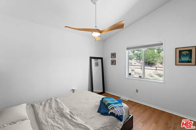 a bedroom with a bed a window and a chandelier