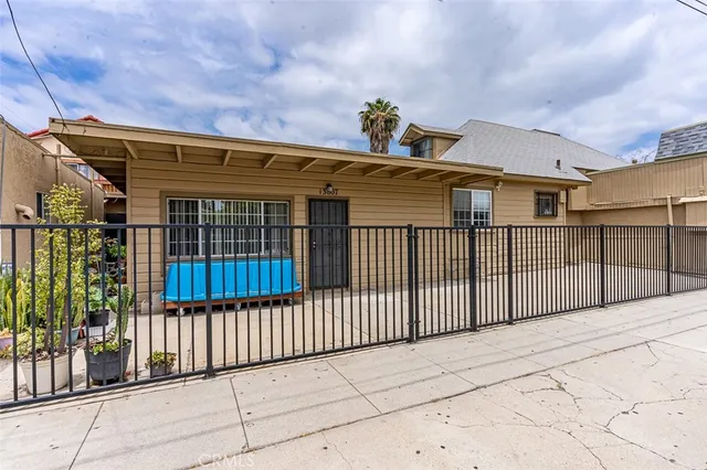 a view of a brick house with wooden fence