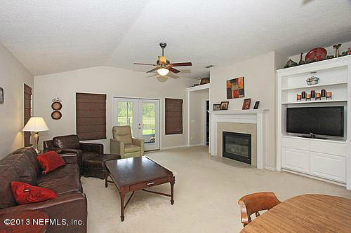 609 Racoon Court St. Johns, FL 32259 - Photo 7 of 32 a living room with furniture a flat screen tv and a fireplace