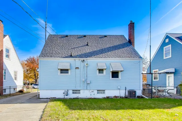 a view of a house with a big yard plants and large tree