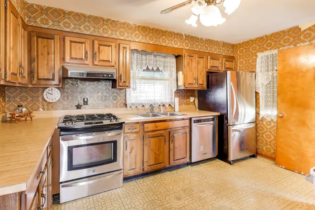 a kitchen with stainless steel appliances granite countertop a stove a refrigerator and a microwave