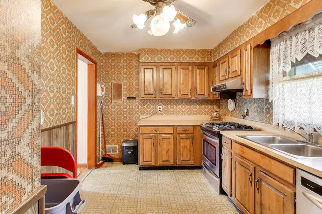 a kitchen with stainless steel appliances granite countertop a sink stove and cabinets
