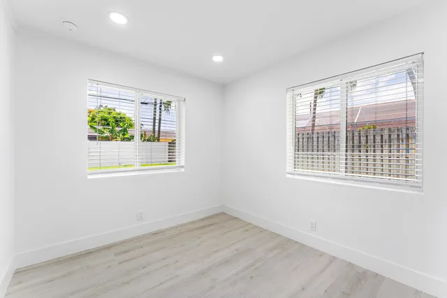 an empty room with wooden floor and window