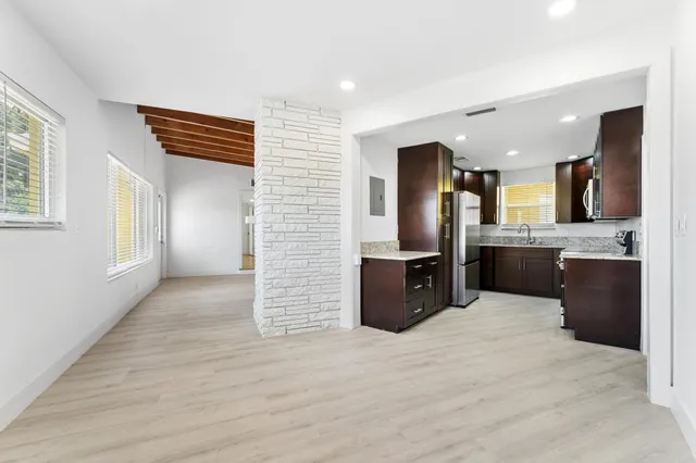 a kitchen with stainless steel appliances kitchen island granite countertop a refrigerator and a sink