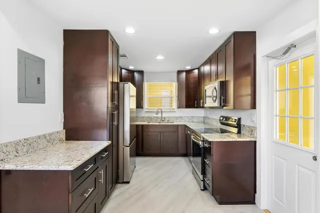 a kitchen with a stove a refrigerator and a sink