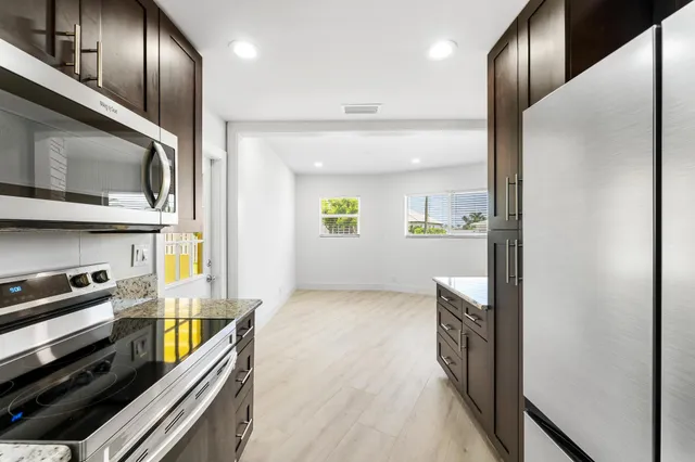 a kitchen with stainless steel appliances granite countertop a refrigerator and a stove