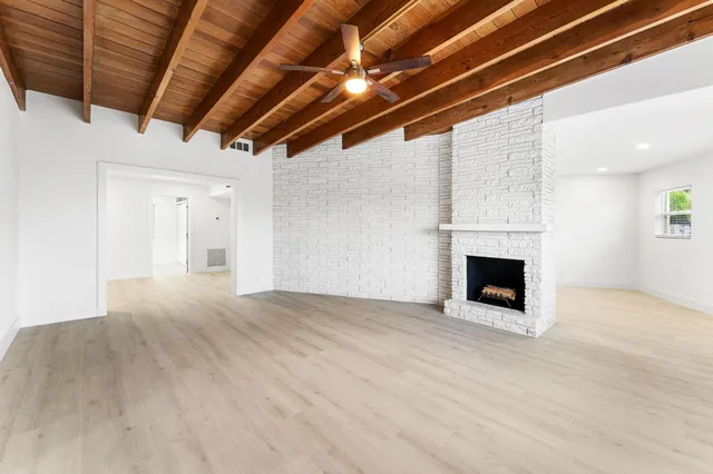 a view of empty room with wooden floor and fireplace