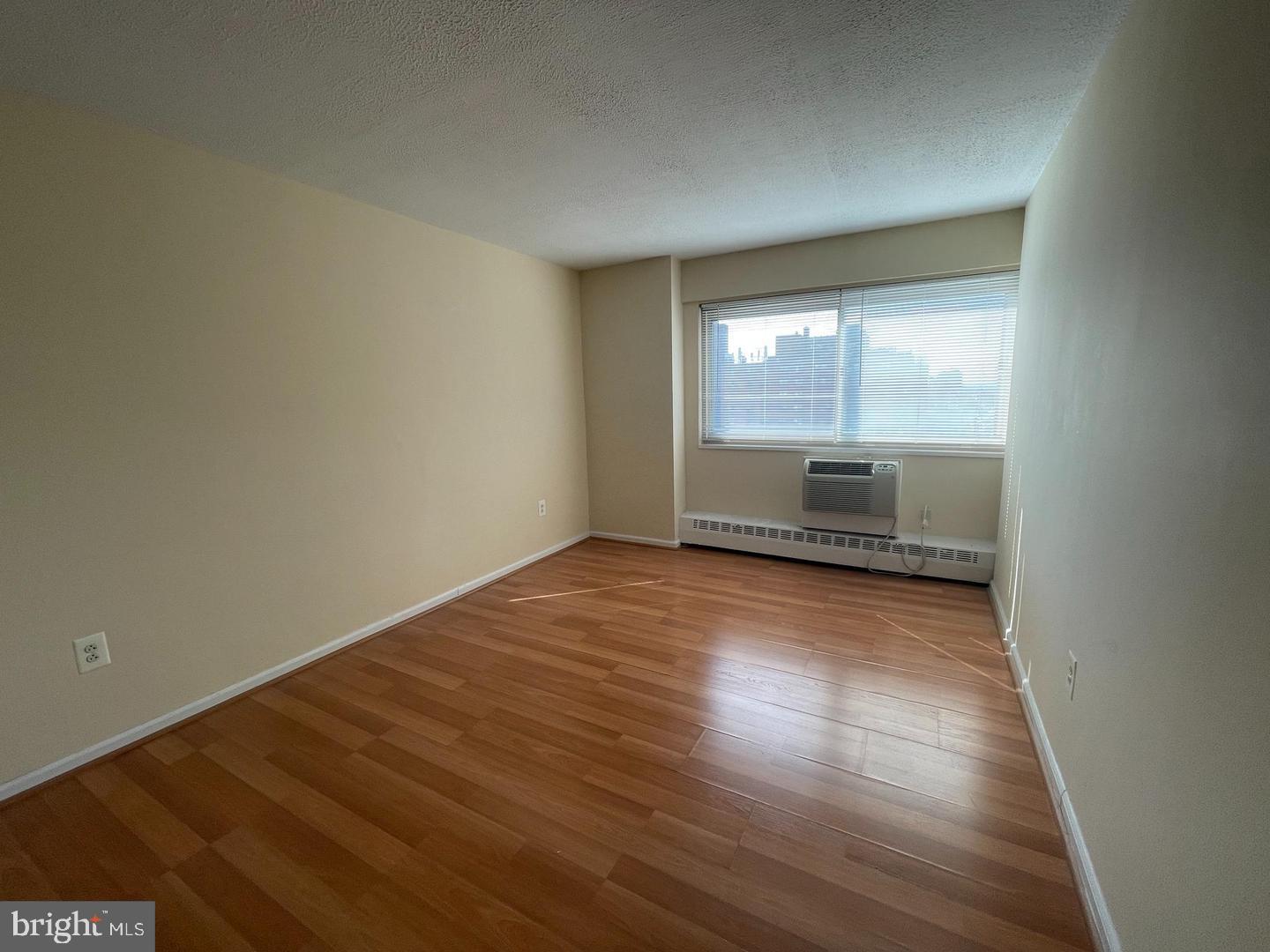 2101 Chestnut Street, Unit 1413 Philadelphia, PA 19103 - Photo 2 of 13 an empty room with wooden floor and windows