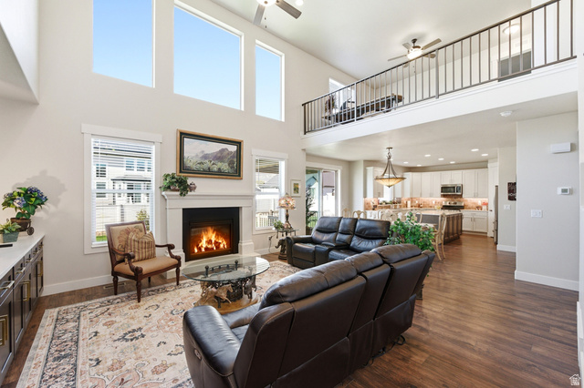 1434 West Stable Street Lindon, UT 84042 - Photo 7 of 76 Living room with dark wood-type flooring, a glass covered fireplace, a ceiling fan, a high ceiling, and recessed lighting