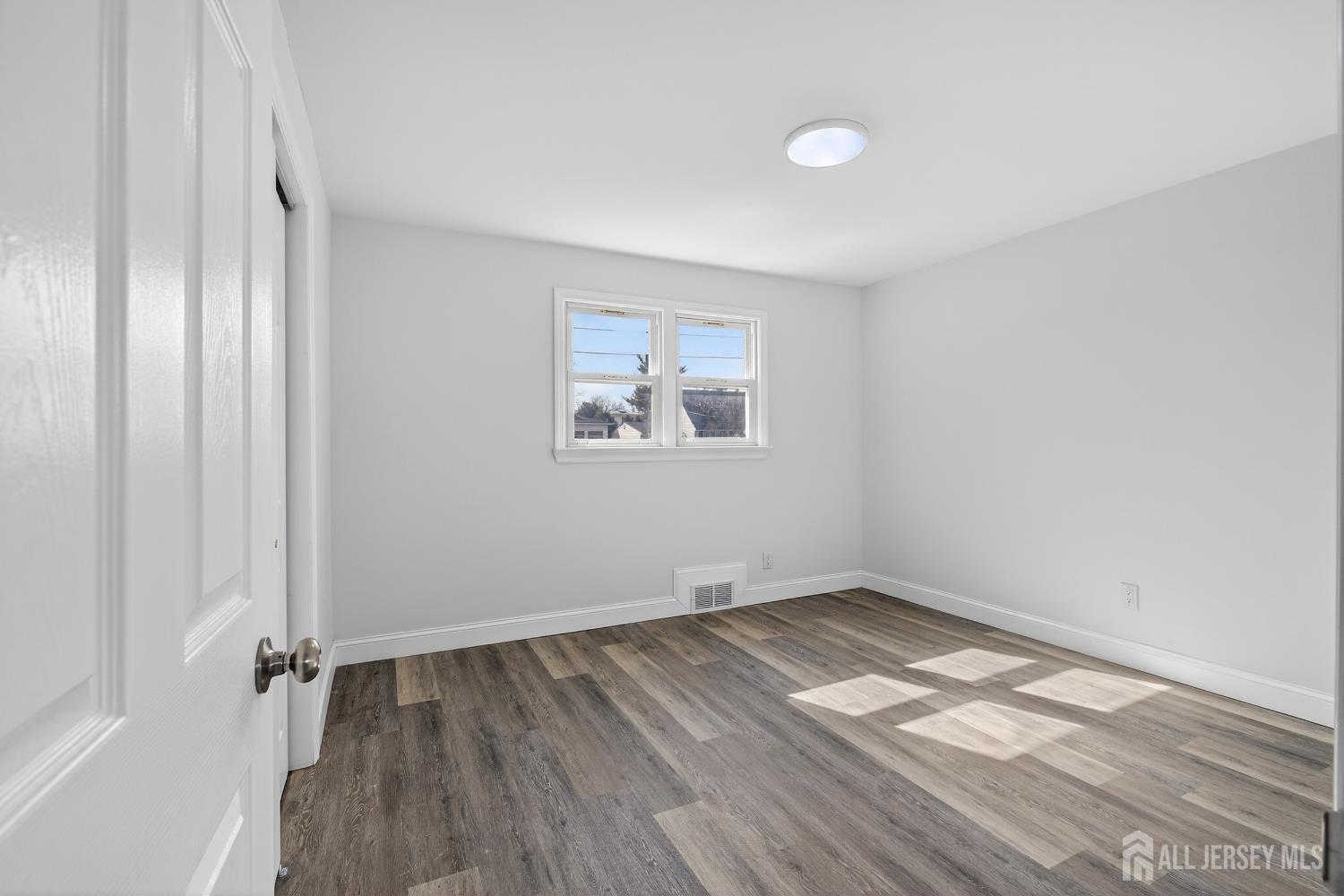 12 North Pennington Road New Brunswick, NJ 08901 - Photo 37 of 50 an empty room with wooden floor and windows