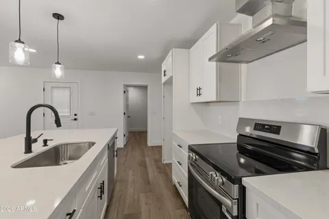 an empty room with wooden floor ceiling fan and windows