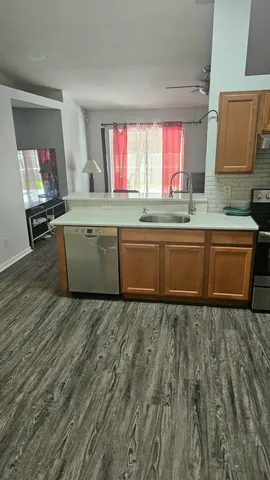 a room with granite countertop a sink and a wooden floor
