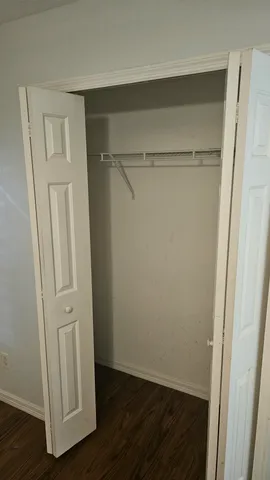 a view of walk in closet with wooden floor