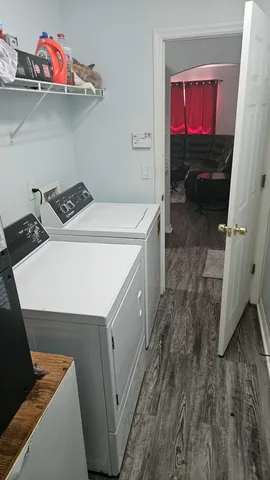 a utility room with dryer washer and a view of living room