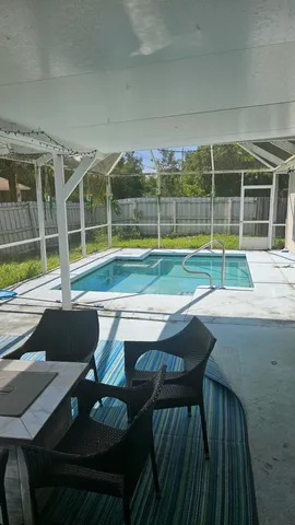 a view of a house with pool and a yard