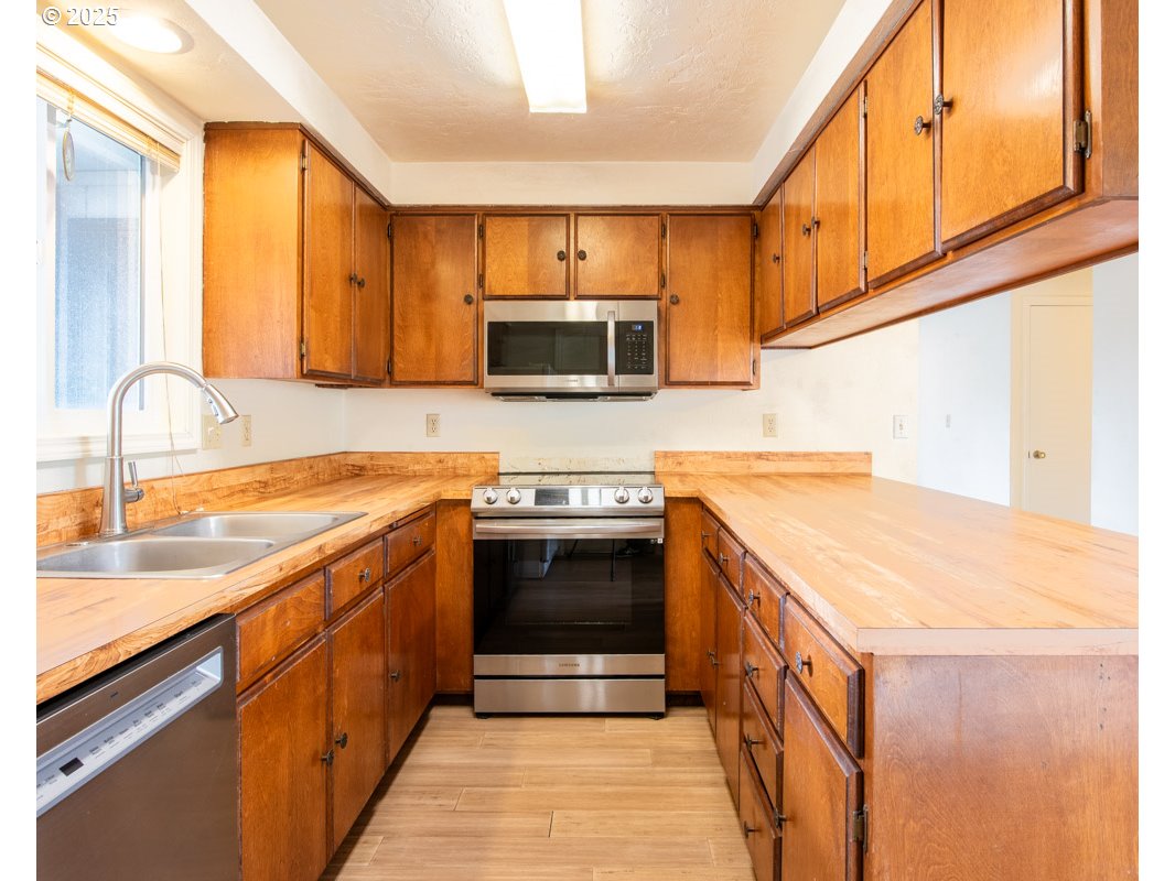 4631 Daisy Street Springfield, OR 97478 - Photo 12 of 46 a kitchen with stainless steel appliances granite countertop a sink and a stove top oven