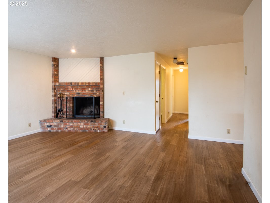 4631 Daisy Street Springfield, OR 97478 - Photo 5 of 46 a view of empty room with wooden floor and fireplace