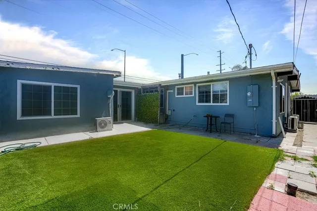 a view of house with backyard outdoor seating and hardwood
