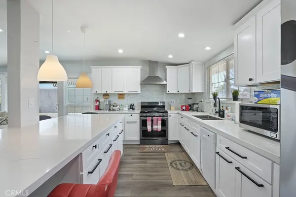 a large kitchen with stainless steel appliances granite countertop a stove a sink and a refrigerator
