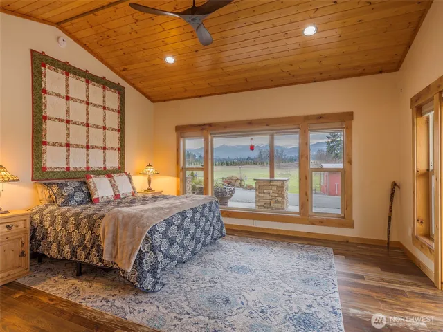 a bed sitting in a spacious bedroom next to a window