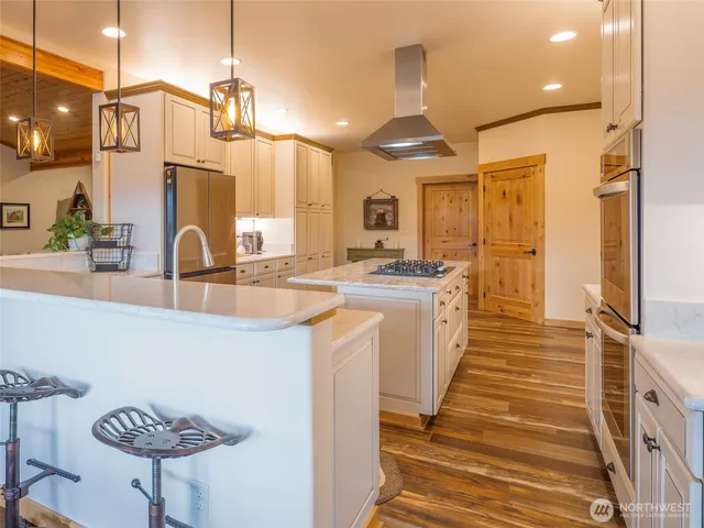 a kitchen with stainless steel appliances kitchen island granite countertop a sink a counter space and cabinets