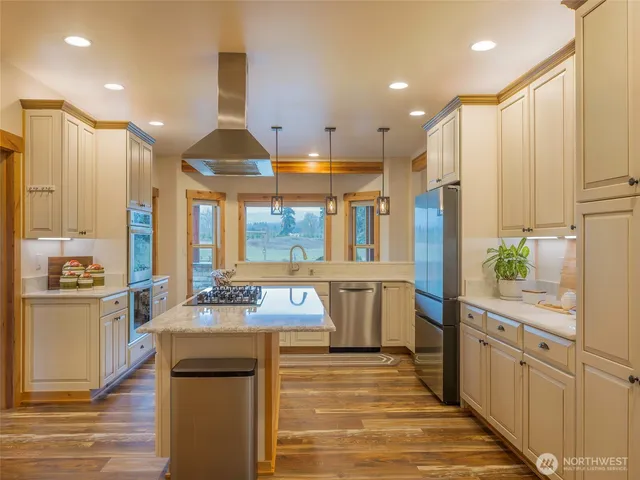 a kitchen with a sink stainless steel appliances granite countertop cabinets and a window