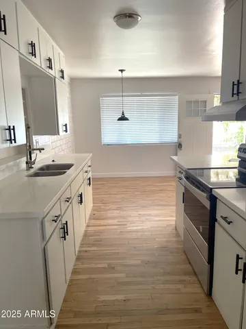 a kitchen with stainless steel appliances a sink dishwasher a refrigerator a stove top oven a counter space and cabinets