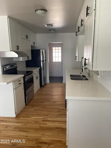 a kitchen with sink a stove and refrigerator