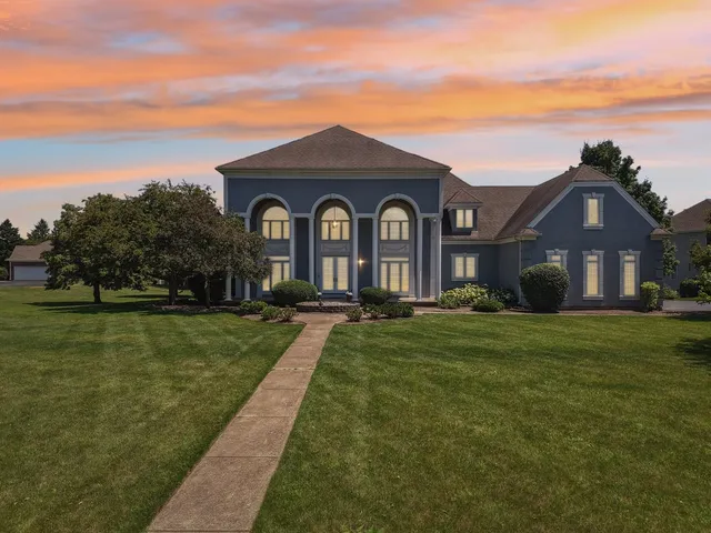 an empty room with wooden floor chandelier fan and windows