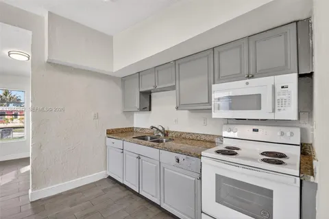 a kitchen with cabinets appliances and a counter space