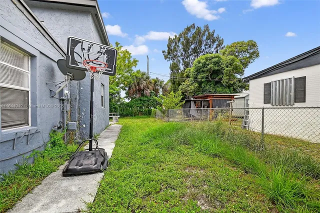 a view of a house with a yard and potted plants