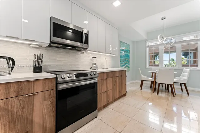 a kitchen with stainless steel appliances a stove microwave and sink