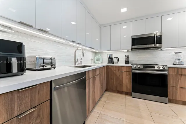 a kitchen with stainless steel appliances a refrigerator sink and cabinets