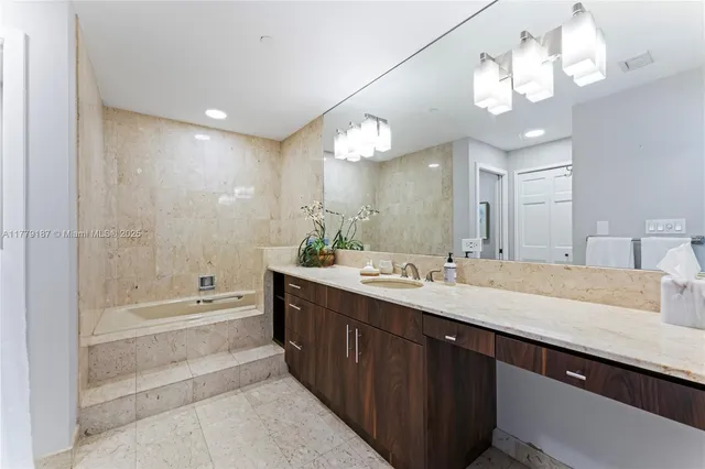 a spacious bathroom with a granite countertop sink a toilet a tub and shower