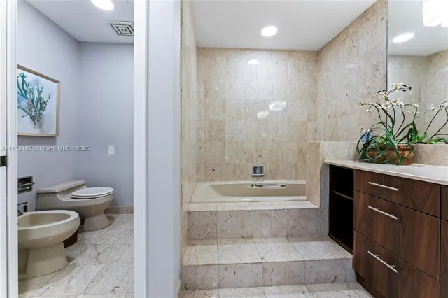 a spacious bedroom with a bed and a flat screen tv