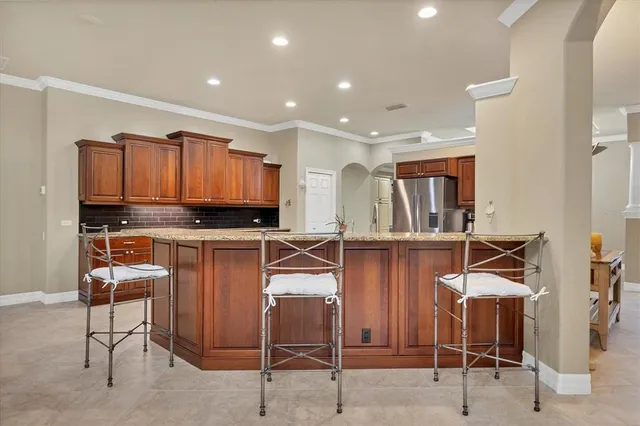 a kitchen with stainless steel appliances kitchen island granite countertop a refrigerator and cabinets