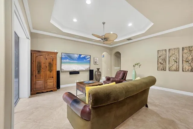 a living room with furniture a ceiling fan and a window