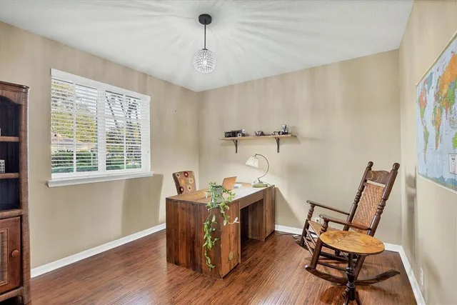 a view of a workspace with furniture and a window