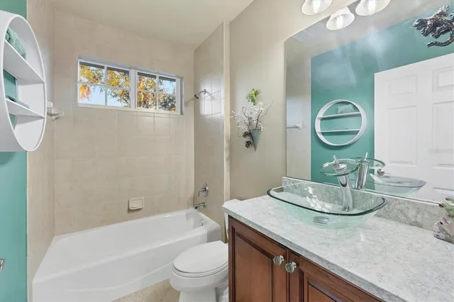 a bathroom with a granite countertop sink a toilet a vanity and bathtub