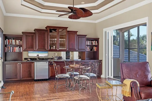 a kitchen with stainless steel appliances granite countertop a stove top oven a dining table and chairs with wooden floor