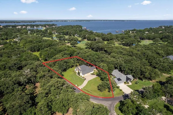 an aerial view of a house with a yard and lake